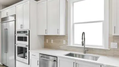 Gorgeous kitchen with tons of space to prepare!  48" counter depth refrigerator, built in microwave & oven + gas cooktop! White cabinets are an upgrade available to add early in construction.