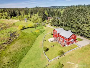 An aerial view of the fenced in portion of the 4.9 acres. Note the neighbor's cows in the background. With your permission, they may wander down and visit you, too!