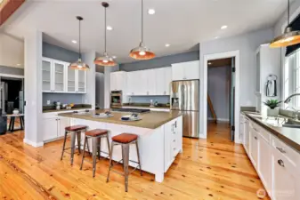Note the large island with bar seating, endless cabinet and storage space, and the walk in pantry at the rear.
