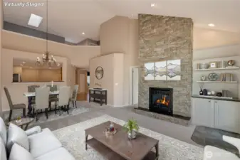 Just beyond, the cozy family room invites you to relax and unwind. [Photo is virtually staged]