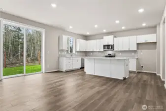 Kitchen view showing large island and view out slider to back yard.