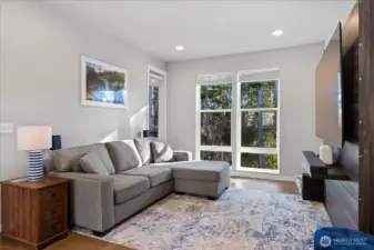 Living area has large windows facing greenbelt & balcony access.