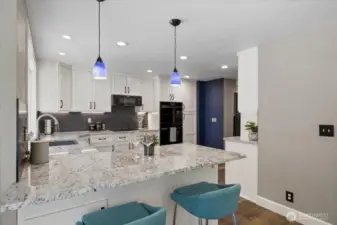 Open kitchen bar area with storage underneath and custom Pendant lighting. Beautiful thick Granite counters throughout!