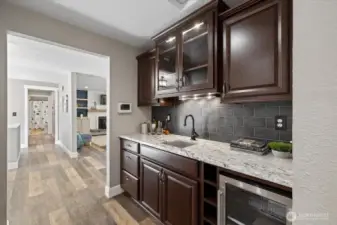 Well designed Butler's pantry with Wine fridge and sink! Plenty of cabinetry and Windowed cabinets to show off that stemware!