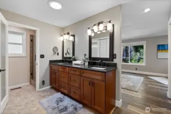 The Primary bathroom with dual vanity, granite counters, rich cabinetry, and a new California closet just recently put in across from the vanity.  A few solar tubes are strategically place to add additional light.
