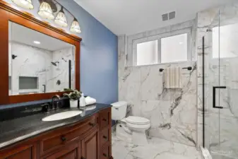 Newly remodeled 3/4 bathroom with heated flooring!  Consistently high-end cabinetry and counters with tiled flooring and beautiful full sized shower!  Easily a second primary bedroom bathroom!