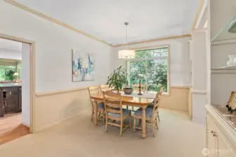 The dining room is centrally located between the kitchen and formal living room and features built-in storage and display shelves—perfect for serving pieces, seasonal décor, or your favorite glassware. It's a warm, functional space for everyday meals or special gatherings.
