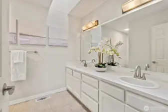 The first hall bathroom features double sinks, generous counter space, and a skylight that fills the room with natural light creating a bright and functional space.