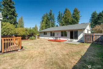 Full fenced backyard has both a patio & deck plus tool shed