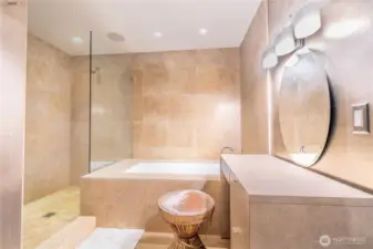 Primary bath is done in  quiet tones- very spa-like with a soaking tub, vanity, large shower and two sinks.