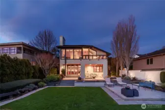 Night shot illustrates the walls of windows, the soaring ceilings and beautiful beams. Private backyard offers serenity and security.