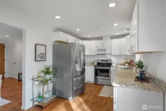 The kitchen offers white shaker cabinets, granite counters, stainless appliances, and a new French door refrigerator