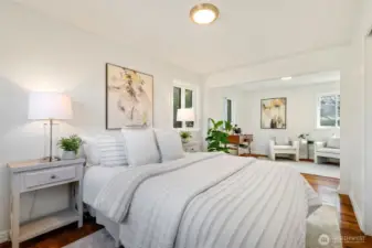 On the main level, the spacious primary bedroom combines two bedrooms into one generous retreat