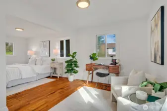 The primary has hardwood floors, four windows flooding in light and dual closets