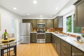 Remodeled kitchen with quartz counters and stainless steel appliances.