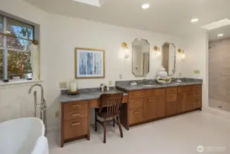 The primary bathroom is well-appointed with spacious double vanities plus additional vanity seating space.