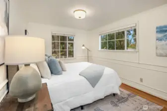A second bedroom upstairs enjoys corner windows with pretty garden views.