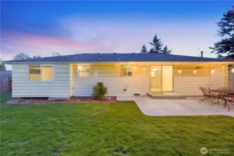 Twilight backyard with patio and lawn