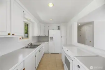 Light filled kitchen with ample storage, tile backsplash and window looking out to the back yard.