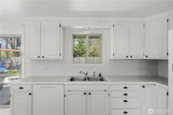 Kitchen with tons of storage and window over looking private, fully fenced backyard.
