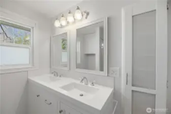 Bright bathroom with double vanity and large window for warm natural light.