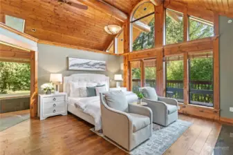 The main level provides three bedrooms, including two breathtaking primary suites. Grandeur and comfort define the first suite, featuring large windows with beautiful views, French doors to the deck, a gas fireplace, and amazing vaulted, tongue and groove ceilings with exposed log beams.