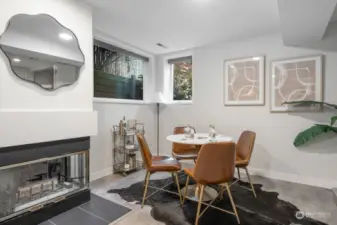 Lower level bonus room with fireplace and vinyl plank flooring.