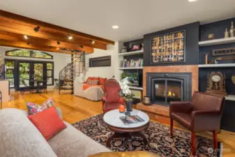 Sitting area of the guest suite enjoys a cozy gas fireplace and gorgeous wood floors.