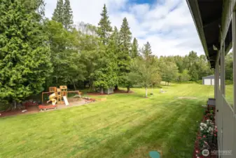 Looking from the deck of the ADU, you can see the beautiful grounds and fun places to play. RV hook ups below also provide space for a 2nd RV if desired. To the back of the property is a second huge shop.