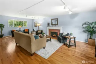 The living room is grand, and lovely. Windows at both ends and the warmth of the wood-burning fireplace set off the space.