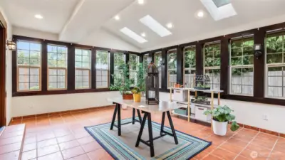 Surrounded by windows, this bright and inviting space seamlessly connects to the backyard for indoor-outdoor enjoyment.