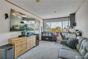 Separate fourth bedroom, currently used as a home office and game room, with large windows and private exterior access.