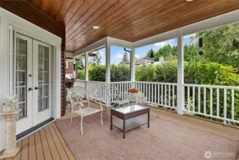 Veranda and large deck looking toward back of house and ADU.  Gorgeous french doors lead from front room to deck.