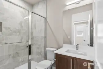 Lower level 3/4 bathroom with full height tile shower.