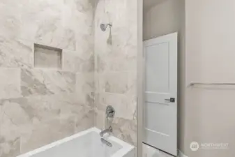 Upstairs hall bathroom with the tub and full height tile surround.