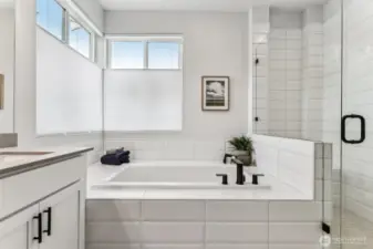 Gorgeous primary bath, deep soaking tub w/gorgeous tile surround and 2 large operable windows.