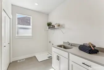 Upstairs laundry room w/quartz counter, sink and cabs.  Large storage/linen closet and operable window.