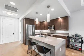 Breakfast bar island with the quartz extending to a waterfall edge. Quite elegant.