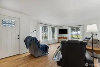 Large windows in living room.  New flooring, paint and custom trim throughout.