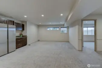 Lower living w wet bar & a peek at right to the 4th bedroom - Fiber high speed Cable in this home