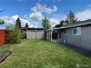 The fenced back yard has a deck and patio.