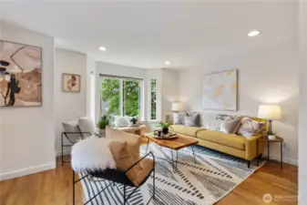 Oak hardwood floors, bay window, and tons of natural light make this living space feel like a standalone house