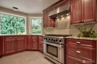 Kitchen that is light and bright with stainless steel appliances and heater tile flooring.