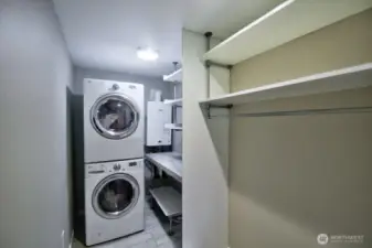 utility room that offers stackable washer/dryer and storage for all your needs.