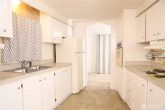 The kitchen opens up toward the dining area, with the second refrigerator clearly visible in this view. Brand new garbage disposal.