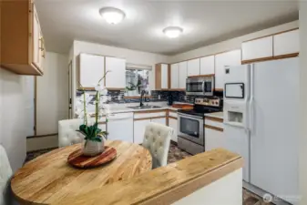 The kitchen has extra cabinets and a great eating area. Stainless stove and microwave.