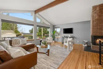 Mid-century style living - refinished original hardwoods, open beams and original angular styled 3-sided fireplace.