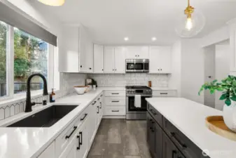 No detail missed here - new cabinets, sleek quartz countertops, deep single sink, stainless appliances, gas cooking, full height tile backsplash, new flooring & designer lighting - with views of the new (2022) entertaining deck - what more can I say?.....except....tons of brilliant storage!