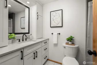 The hall bath is filled with fresh luxe updates - new vanity & storage, tiled floor, stylish tiled tub surround, new fixtures & hardware.