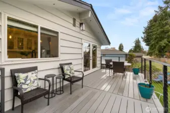 This huge entertaining deck was built in 2022 - views of the yard and pool, and French door access to/from the dining room. The window in the foreground allows the chef to visit with outdoor guests during meal prep.